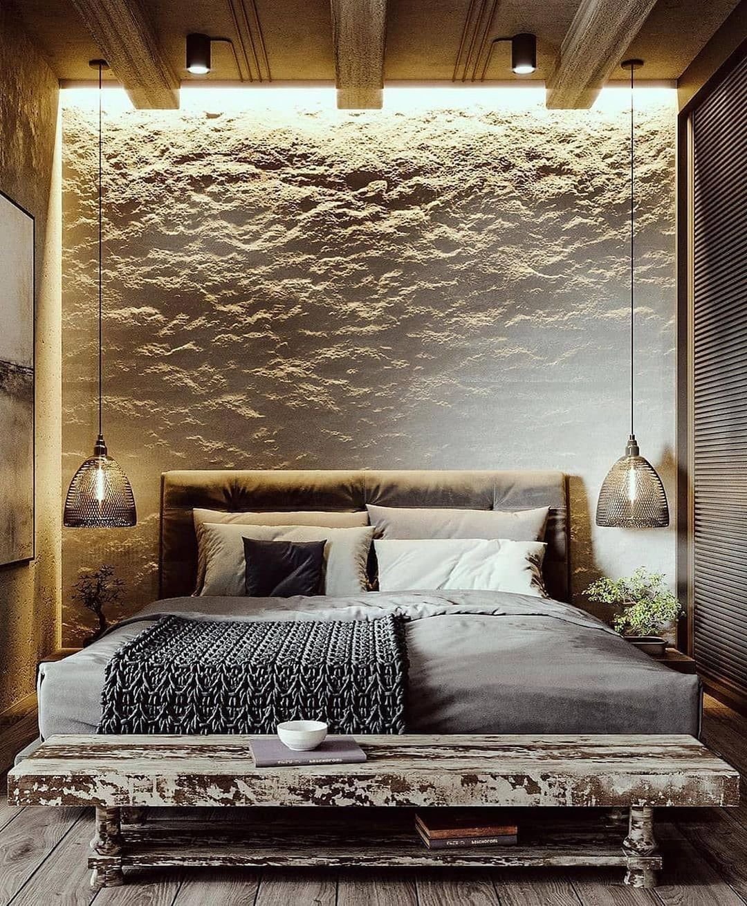 rough textured back wall in a bedroom with a large bed and a distressed looking wooden bench