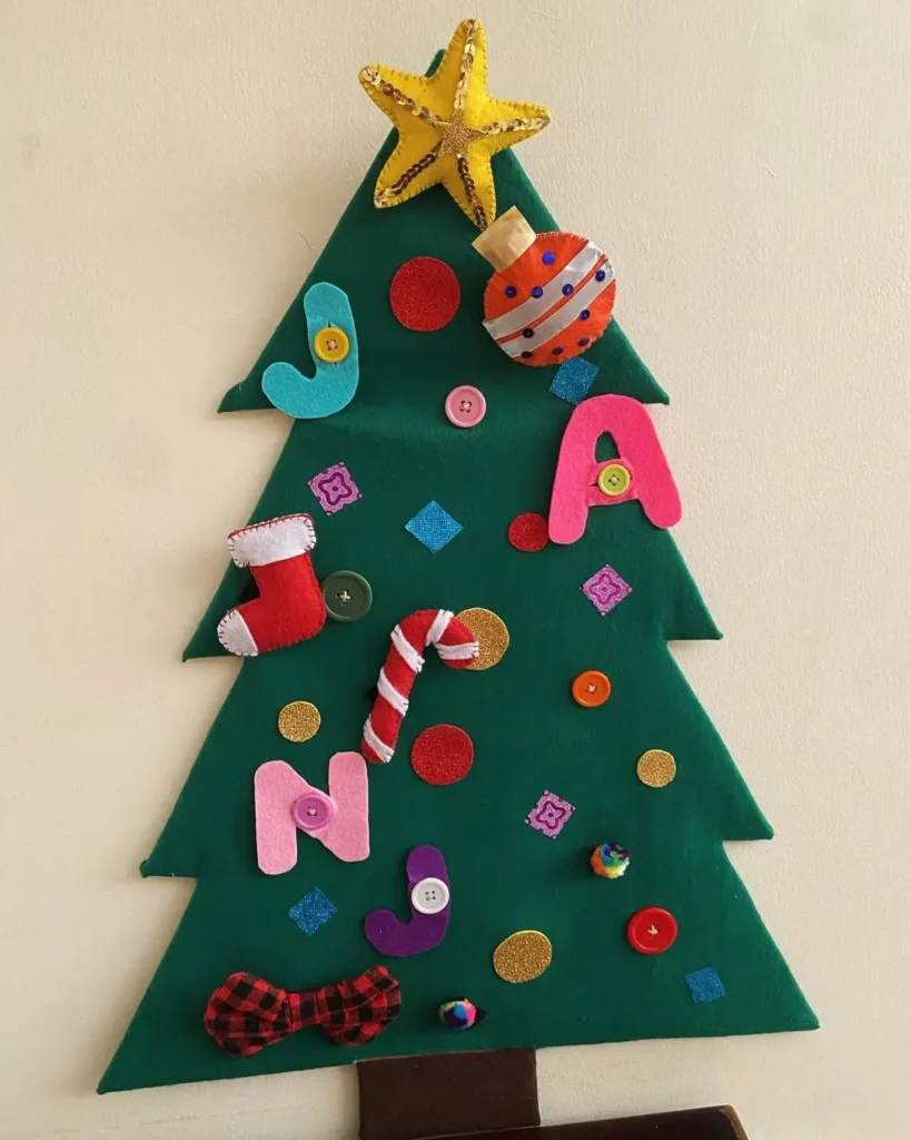 A felt Christmas tree decorated with felt ornaments, letters, buttons, and shapes—including a star on top and a candy cane in the center—is one of 10 adorable kid-friendly Christmas decorations you’ll love.