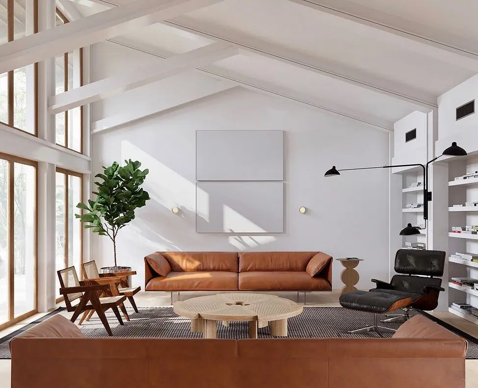 Minimalist mid-century modern living room with brown leather sofas, sculptural lounge chair, round wood coffee table, floor-to-ceiling windows, and clean white walls with warm natural light.